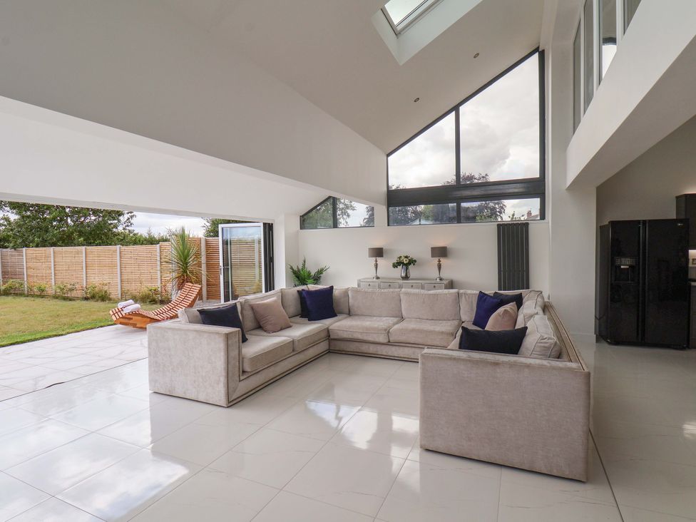 A living room with a sofa and large windows at Mill Cottage in Walkington