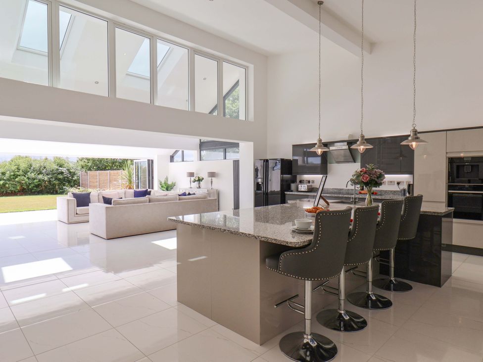 A kitchen with an island and bar stools at Mill Cottage in Walkington