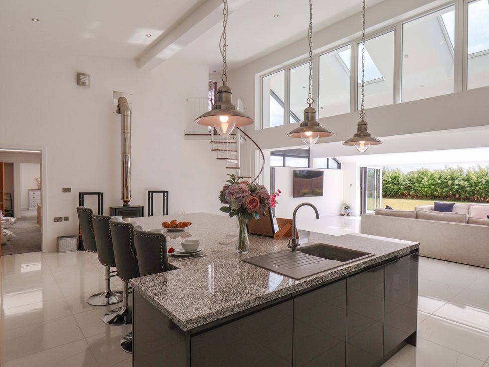 A kitchen with a large island and bar stools at Mill Cottage in Walkington