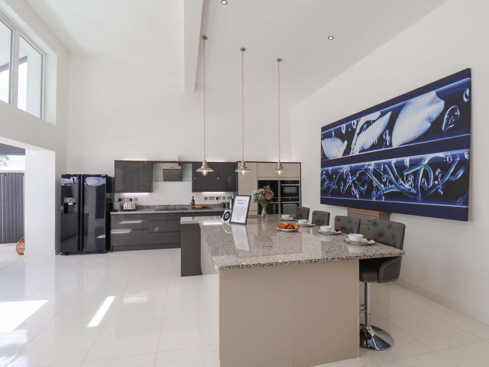A kitchen with a refrigerator and granite countertops at Mill Cottage in Walkington