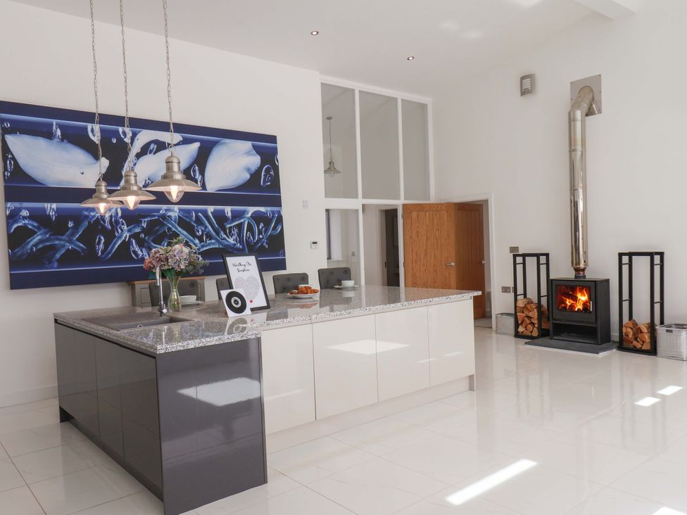 A kitchen with island, fireplace, and wall art at Mill Cottage in Walkington