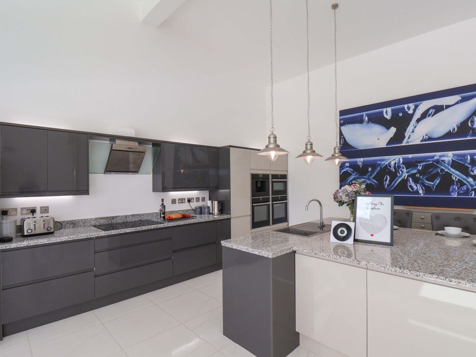 A kitchen with a granite countertop and modern appliances at Mill Cottage in Walkington