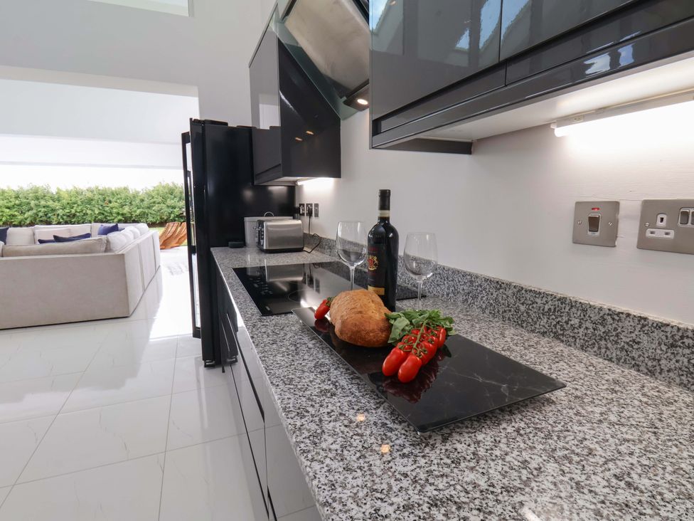A kitchen with a black refrigerator and a cooktop at Mill Cottage in Walkington