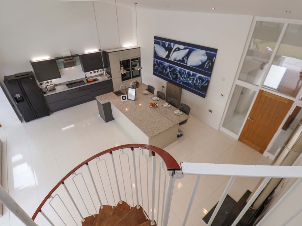 A kitchen with a central island and barstools at Mill Cottage in Walkington