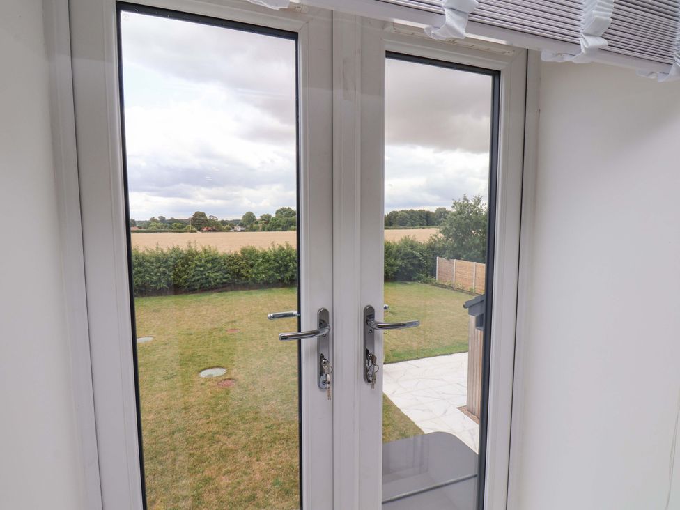 A view of a garden with grass and a fence at Mill Cottage in Walkington