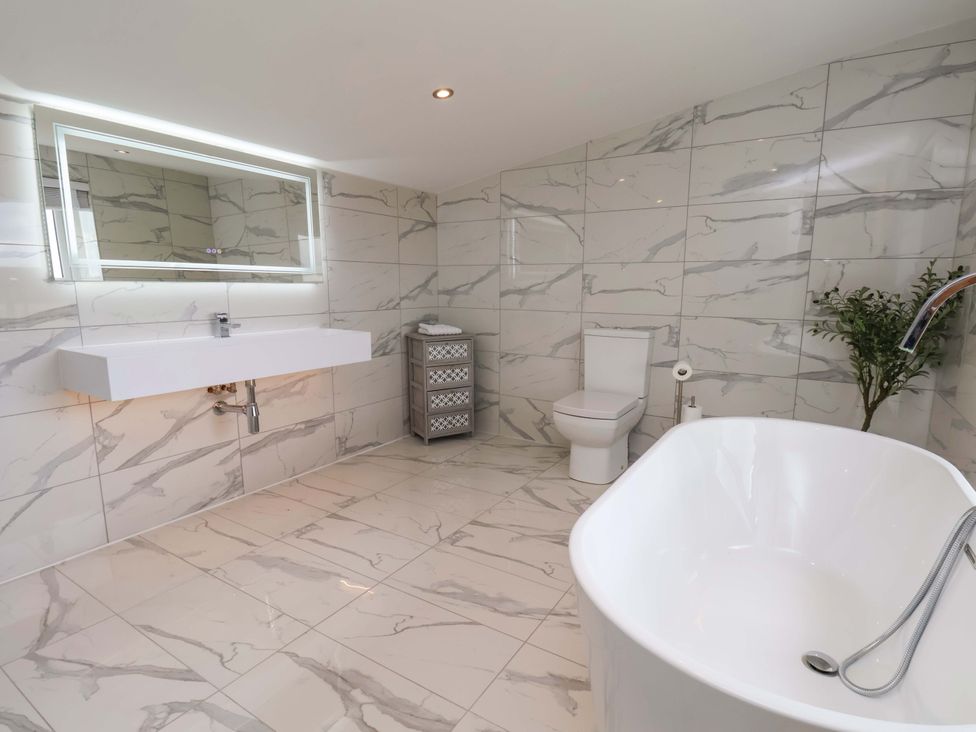 A bathroom with a bathtub, sink, and toilet at Mill Cottage in Walkington