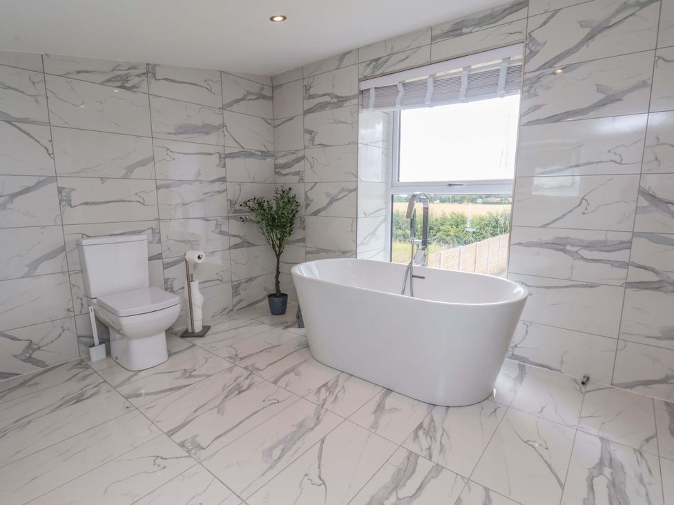 A bathroom with a bathtub and toilet at Mill Cottage in Walkington