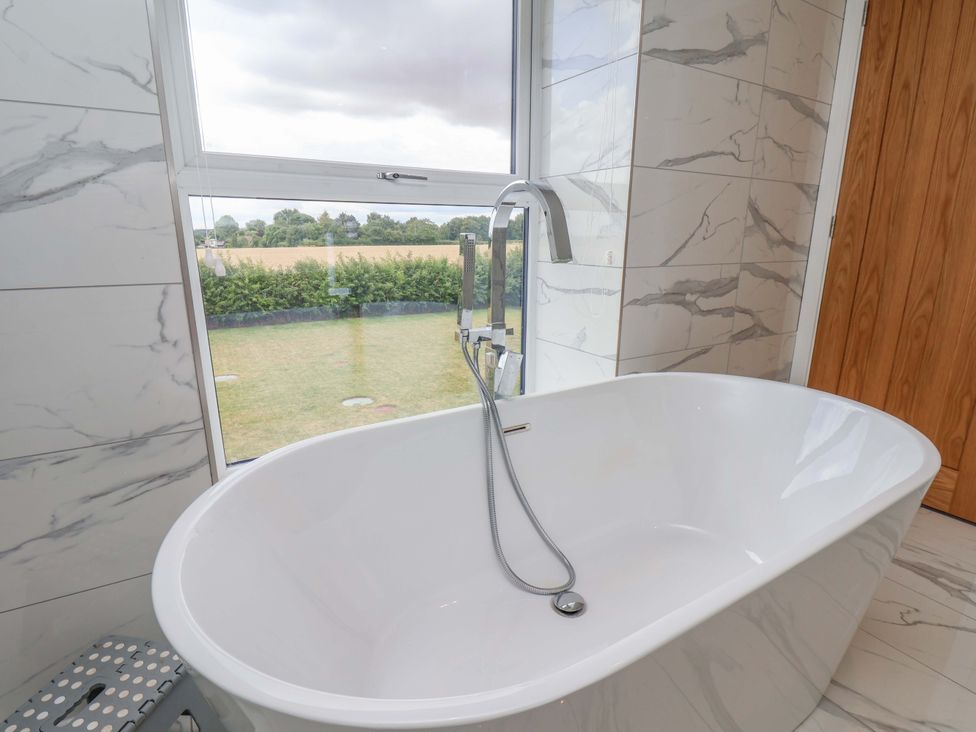 A bathroom featuring a bathtub and window at Mill Cottage in Walkington
