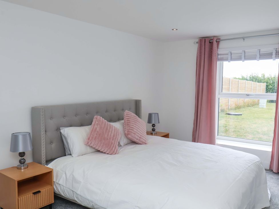 A bedroom with a bed and lamps at Mill Cottage in Walkington