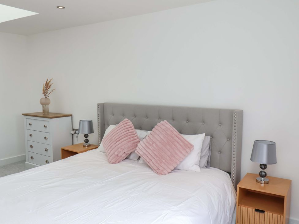 A bedroom with a bed and nightstands at Mill Cottage in Walkington