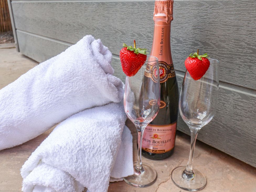 Towels, champagne bottle, and glasses with strawberries at Mill Cottage in Walkington