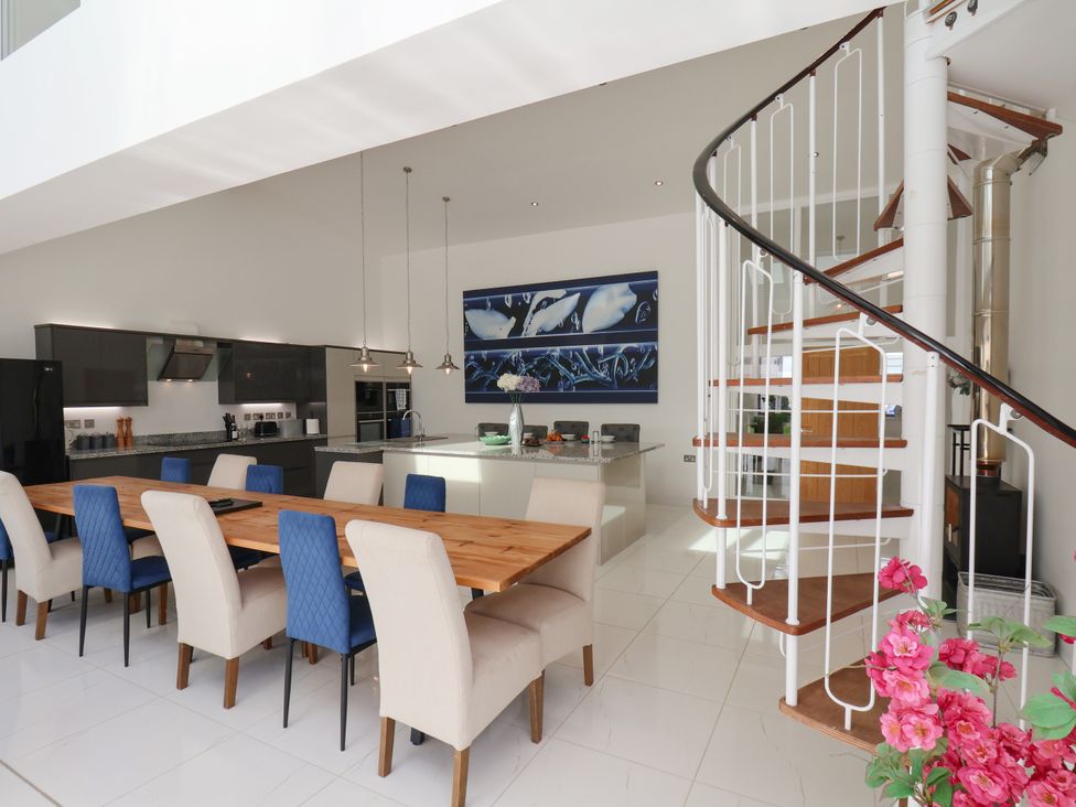 A kitchen with a dining table and spiral staircase at Meadow View Beverley near Walkington