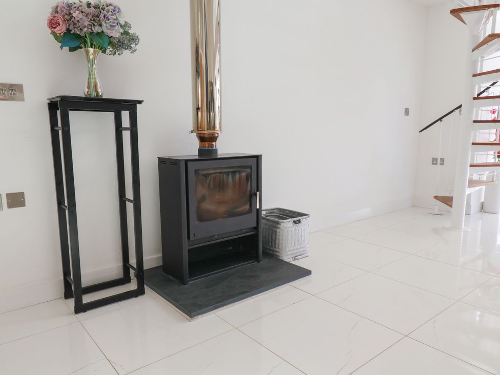 A living room with a wood burner and flowers at Meadow View in Beverley near Walkington