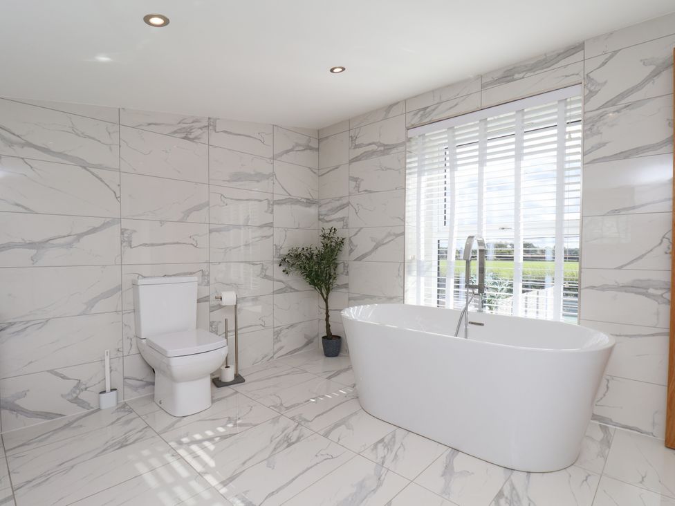 A bathroom with a bathtub and toilet at Meadow View Beverley near Walkington