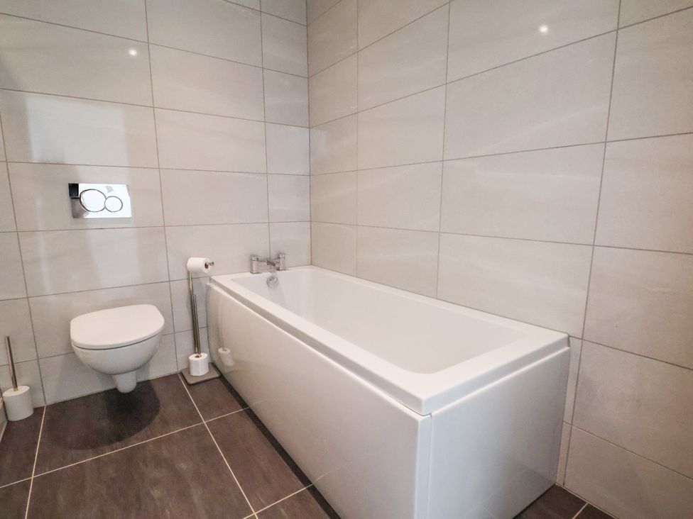 A bathroom with a toilet and bathtub at Meadow View Beverley near Walkington