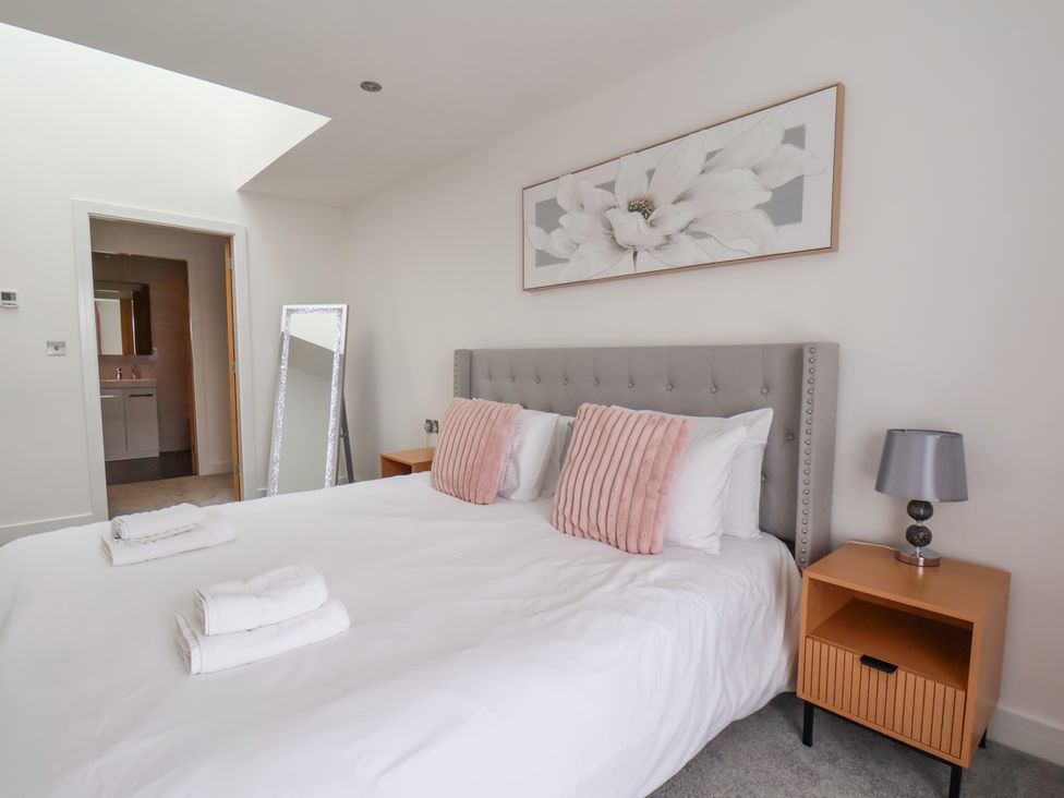 A bedroom with a bed and mirrored furniture at Meadow View in Beverley near Walkington