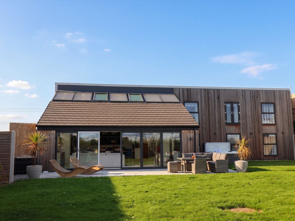 A house with large windows and patio furniture at Meadow View Beverley near Walkington