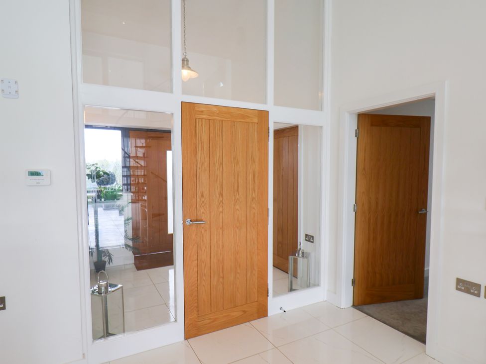 An entrance hall with doors and a mirror at Meadow View Beverley near Walkington