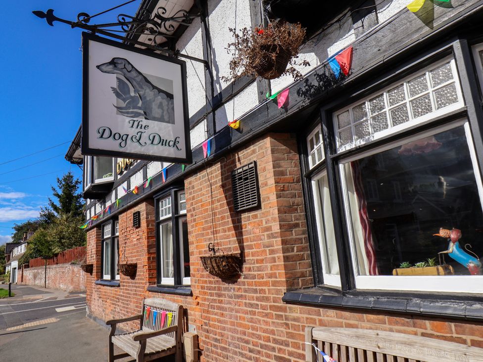 An outdoor view of The Dog & Duck pub with a sign and decorative flags at Meadow View in Beverley near Walkington