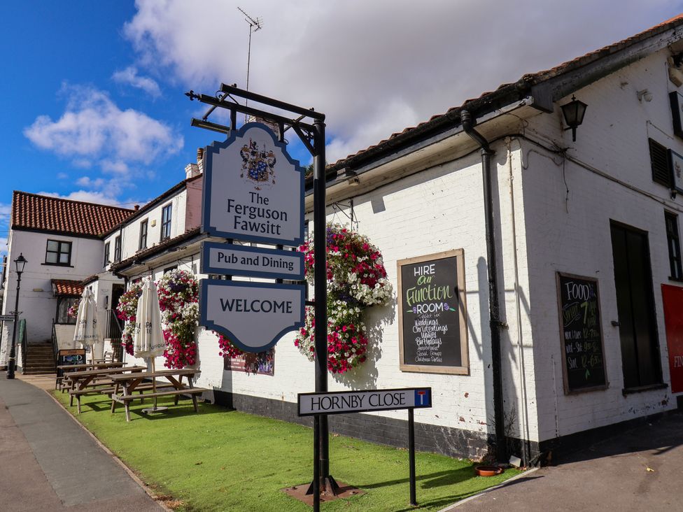 A pub exterior with a sign and outdoor seating at Meadow View Beverley near Walkington