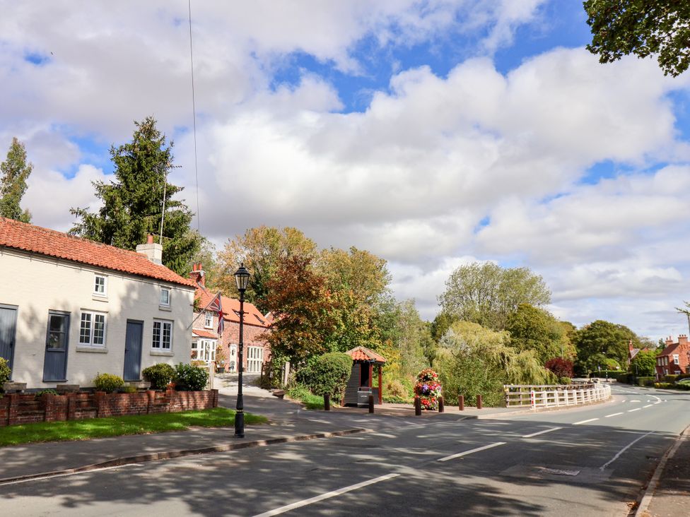 A view of houses along a road with trees and a lamp post at Meadow View Beverley near Walkington