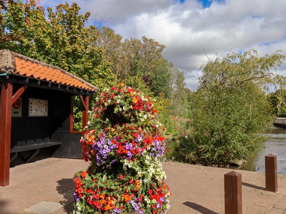 A flower display near a bench and signboard by the lake at Meadow View Beverley near Walkington