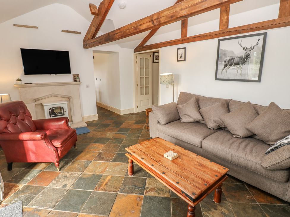 A living room with a television and fireplace at Rainbow Cottage in Kirkby Stephen