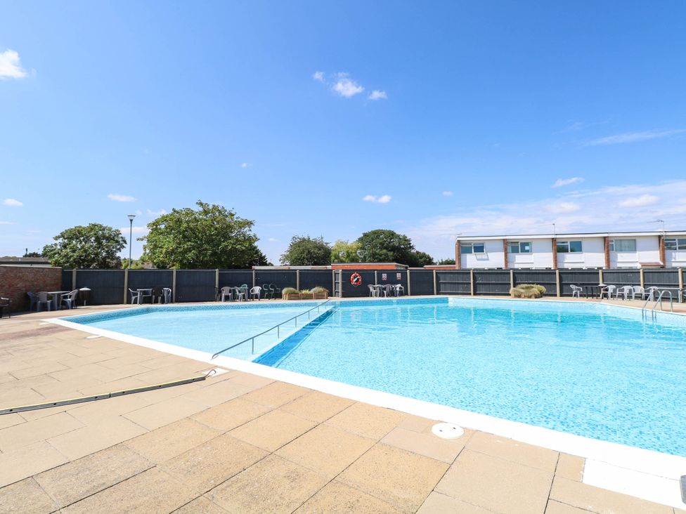 An outdoor swimming pool with deck chairs at 158 Beach Road Chalet Park