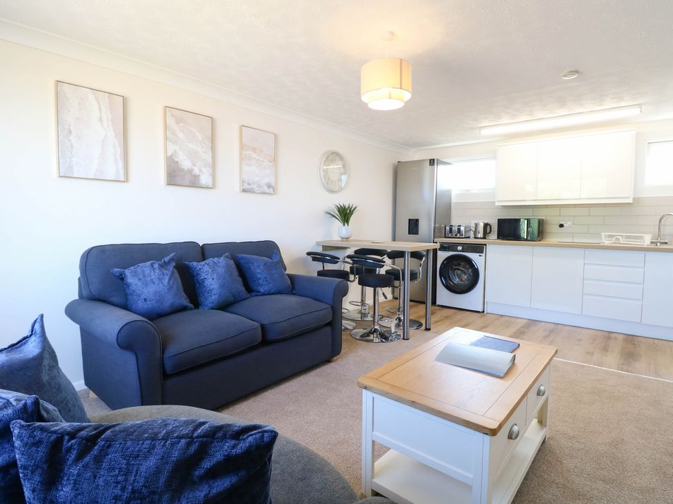 A living room with a sofa and kitchen appliances at 158 Beach Road Chalet Park