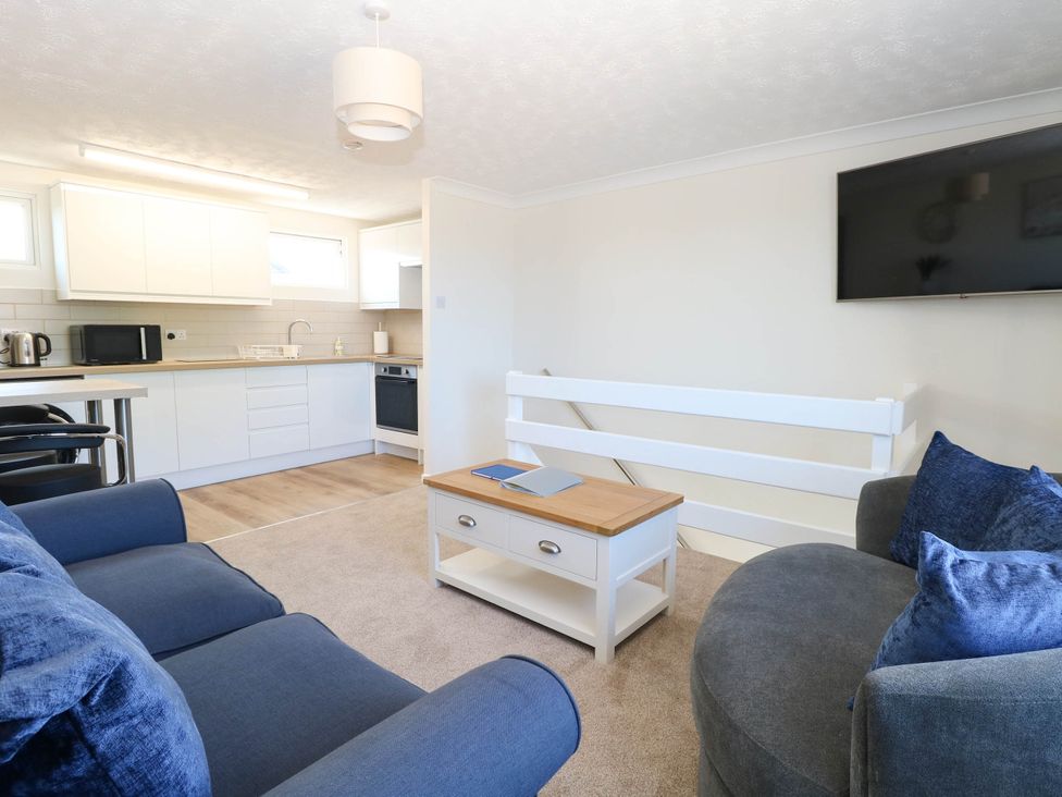 A living room with a kitchen area and television at 158 Beach Road Chalet Park