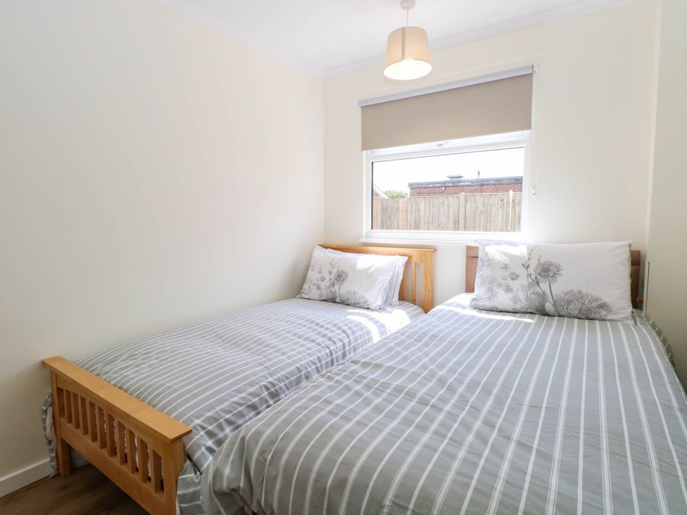 A bedroom with two single beds and a window at 158 Beach Road Chalet Park
