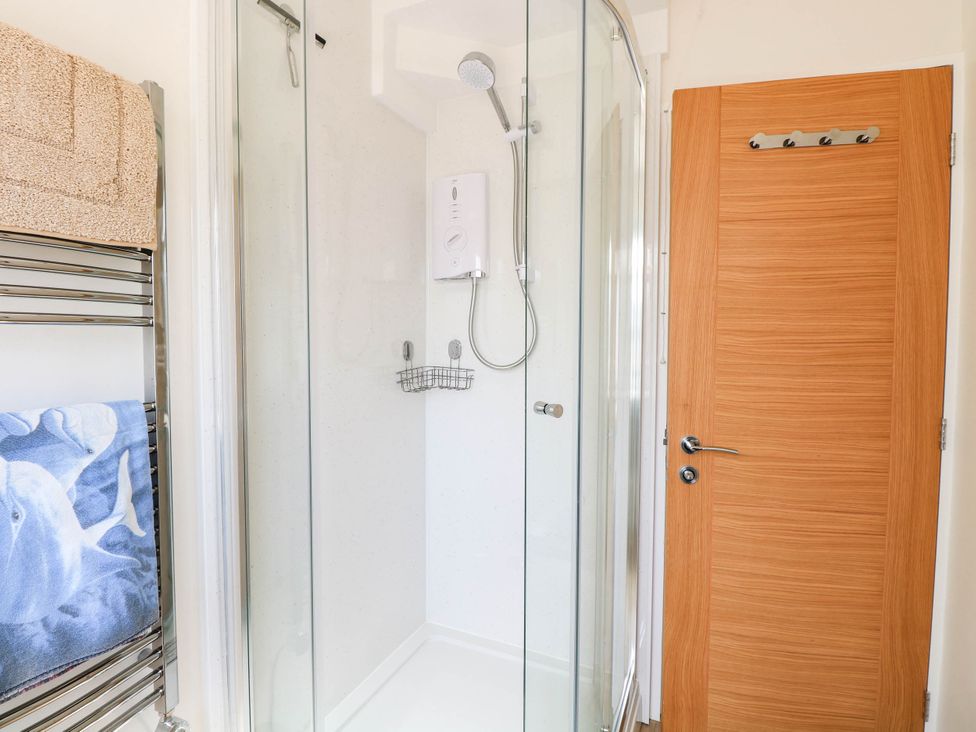 A shower with glass door and towel rack in a bathroom at 158 Beach Road Chalet Park