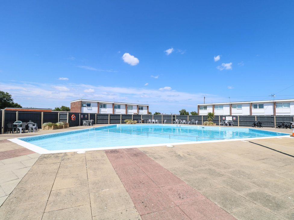 An outdoor swimming pool with sun loungers at 158 Beach Road Chalet Park