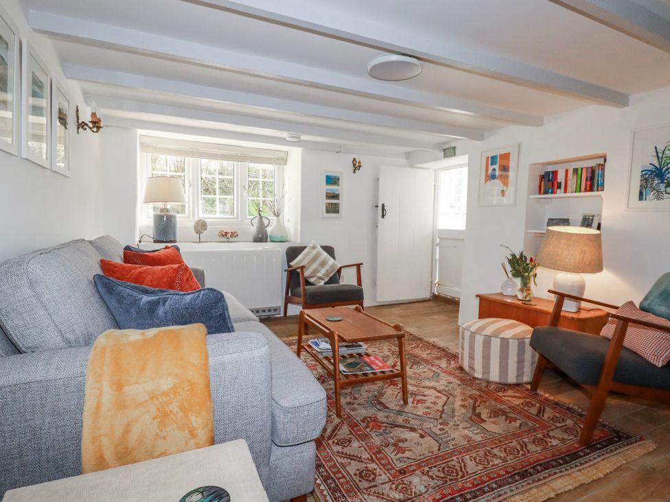 A living room with a couch and a table at Ivy Cottage in Trenale near Tintagel