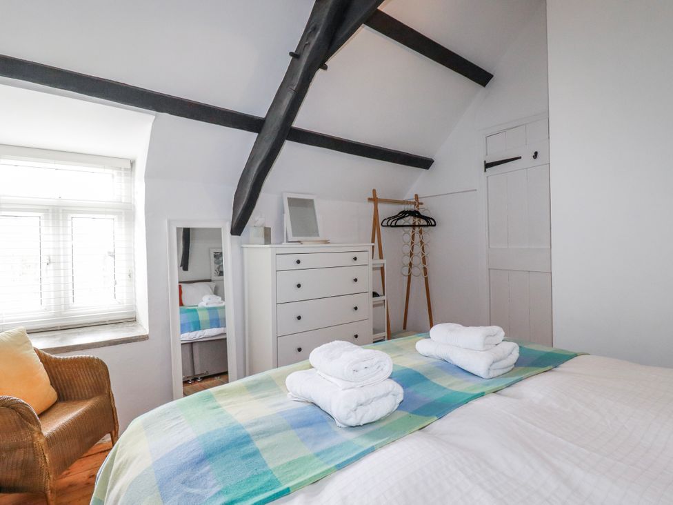 A bedroom with towels on the bed at Ivy Cottage in Trenale near Tintagel