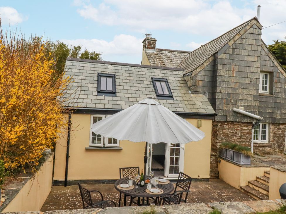 An outdoor dining area with table and chairs at Ivy Cottage in Trenale near Tintagel