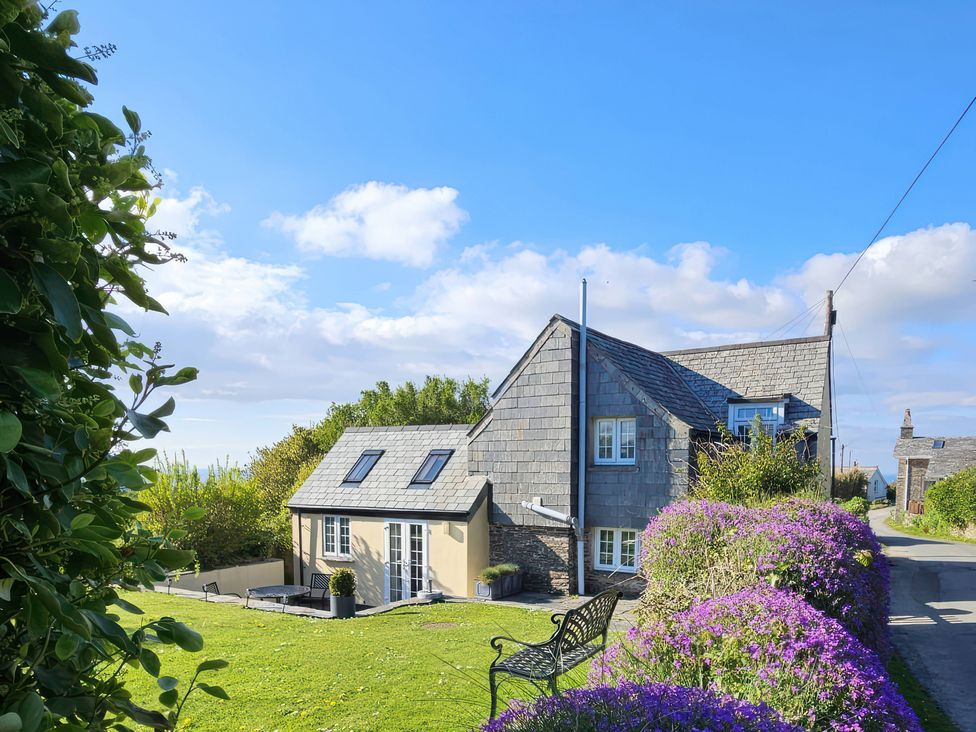 A house with a garden and bench at Ivy Cottage in Trenale near Tintagel