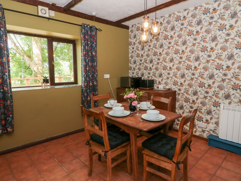 A dining room with a table set for four at The Stable in Llandysul