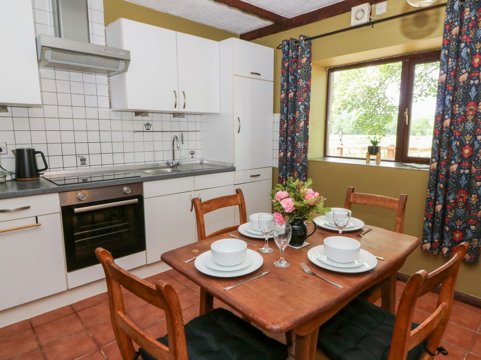 A kitchen with a dining table and chairs at The Stable in Llandysul