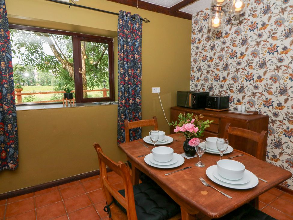 A dining room with a table set for meals at The Stable in Llandysul