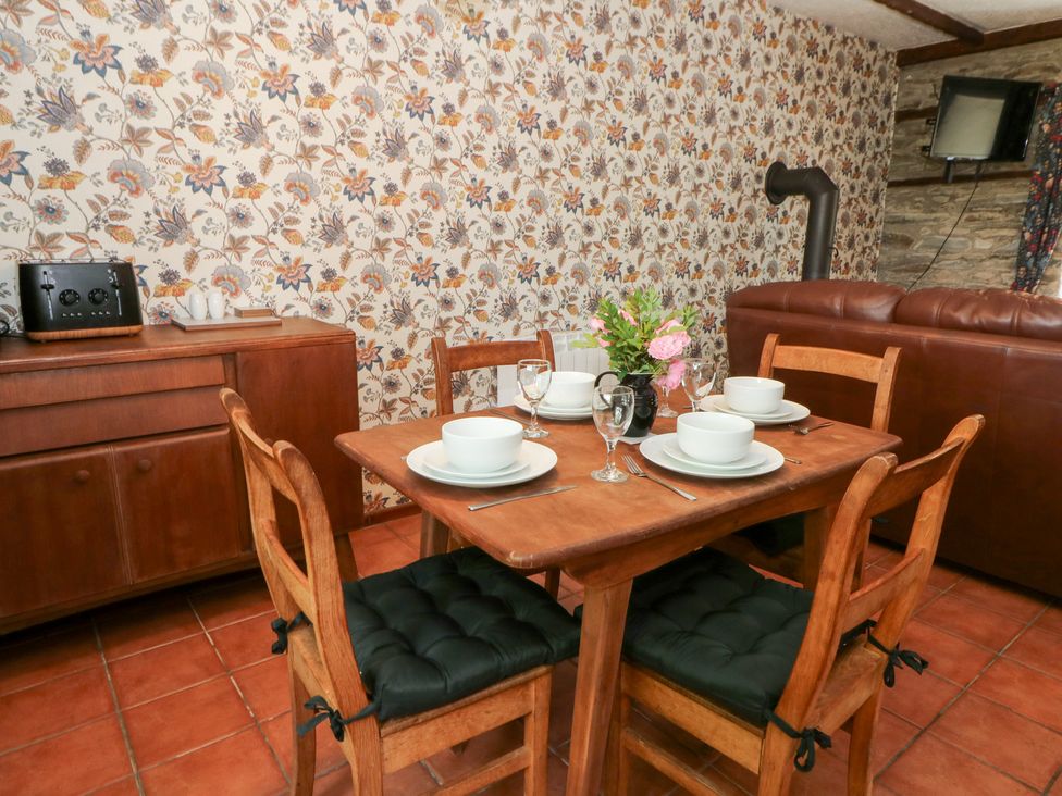 A dining room with a table set for meals at The Stable in Llandysul