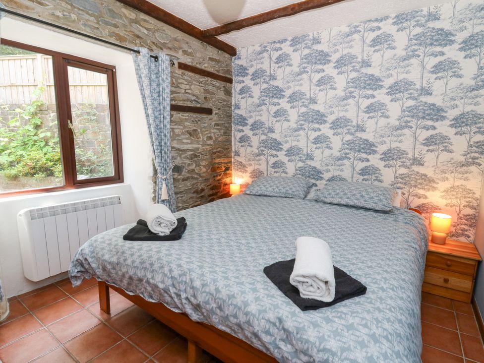 A bedroom with a double bed and window at The Stable in Llandysul