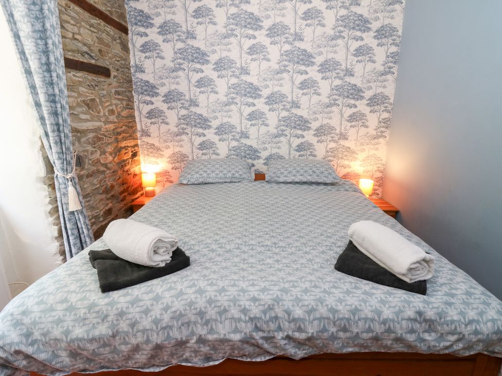 A bedroom with a bed and bedside lamps at The Stable in Llandysul