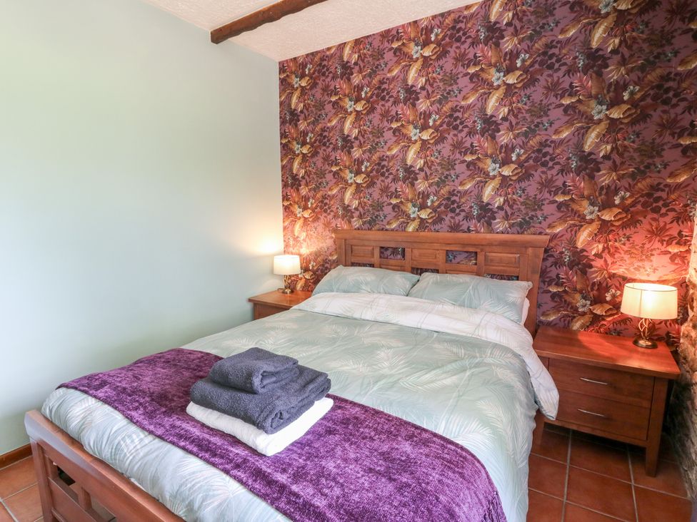 A bedroom with a double bed and bedside table at The Stable in Llandysul