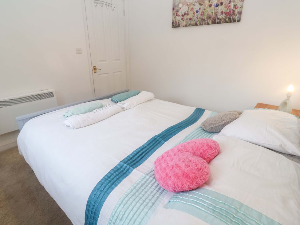 A bedroom with a double bed and decorative pillows at Sandyfeet near Roskear Croft near Camborne