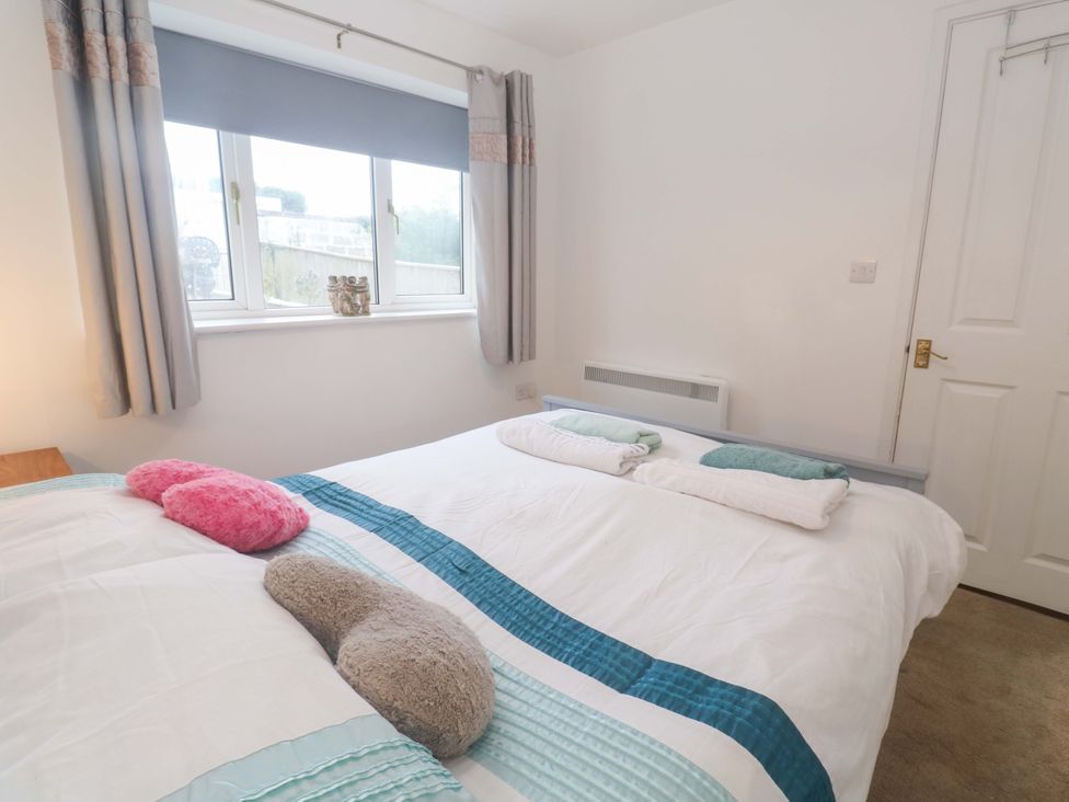 A bedroom with a double bed and window at Sandyfeet in Roskear Croft near Camborne