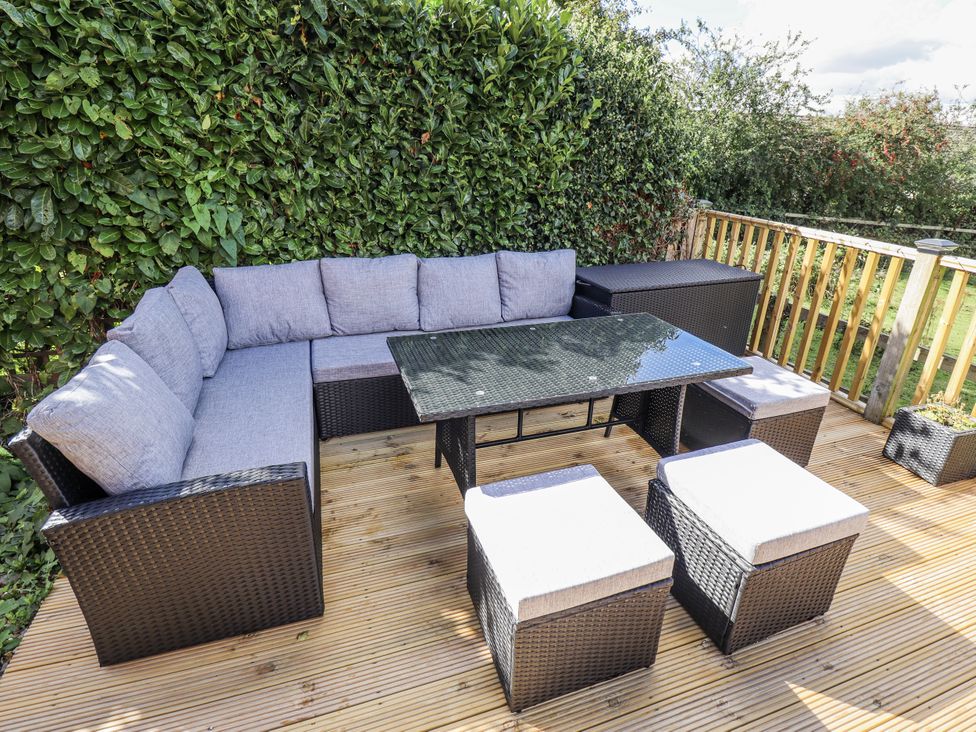 A seating area with a table and cushions at Church View in Withernwick near Aldbrough
