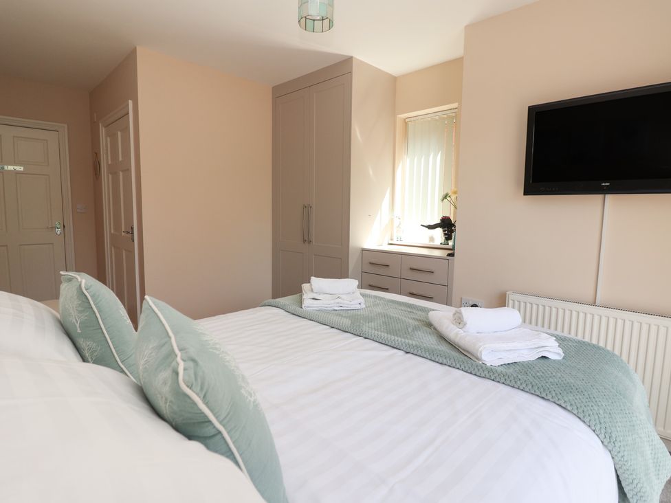 A bedroom with a bed and wardrobe at Church View in Withernwick near Aldbrough