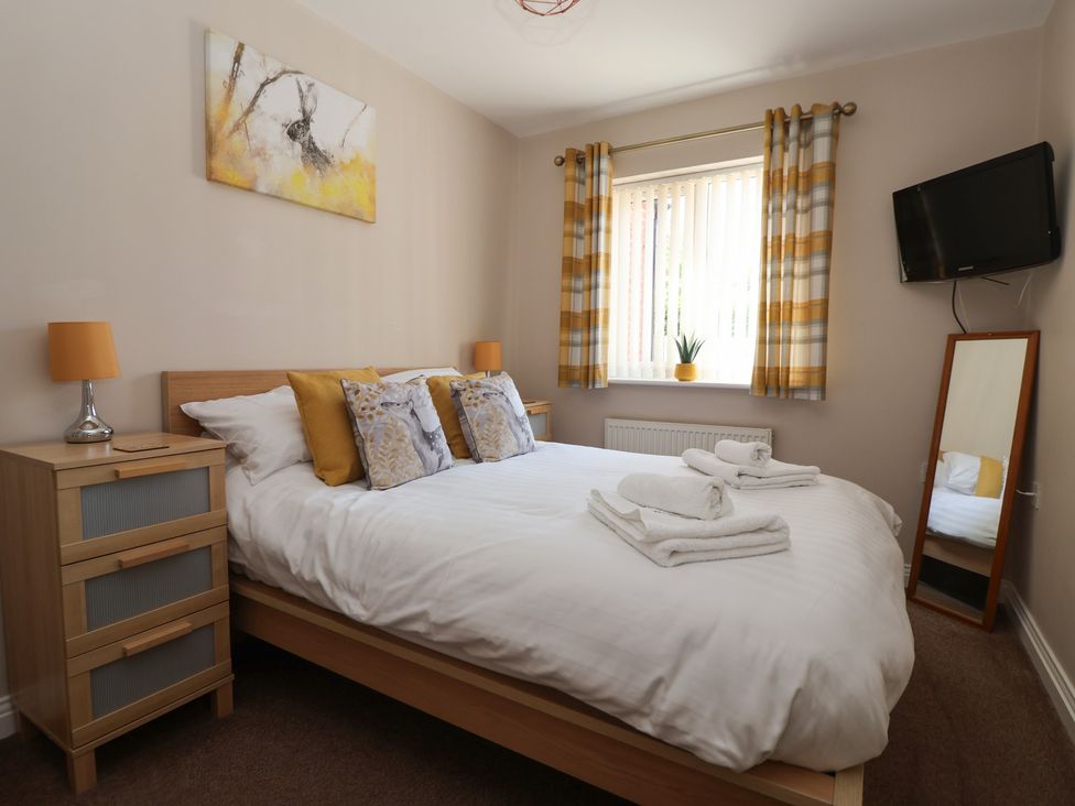 A bedroom with a bed, television, and window at Church View in Withernwick near Aldbrough