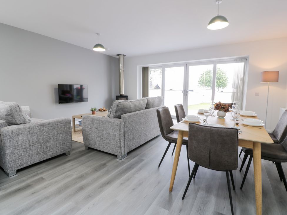 A living room with dining area and television at Beach House in Stranraer